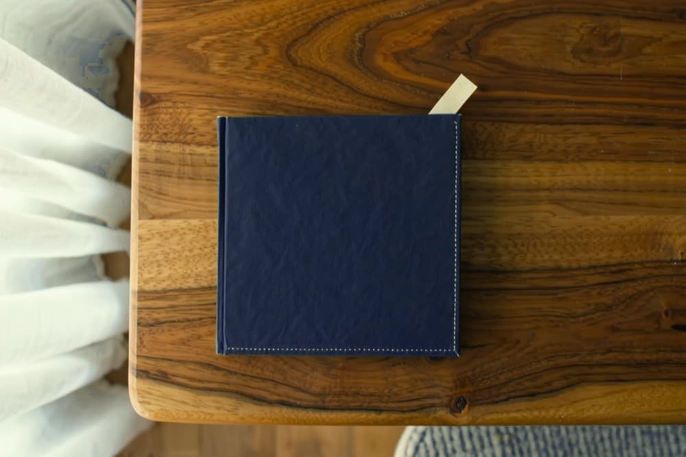 A small booklet with a plain navy cover and a bookmark tab