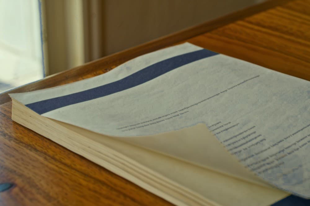 A bound valuation report with a navy cover band on an oak desk